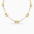 Gold necklace with bow-shaped pendants on a white background