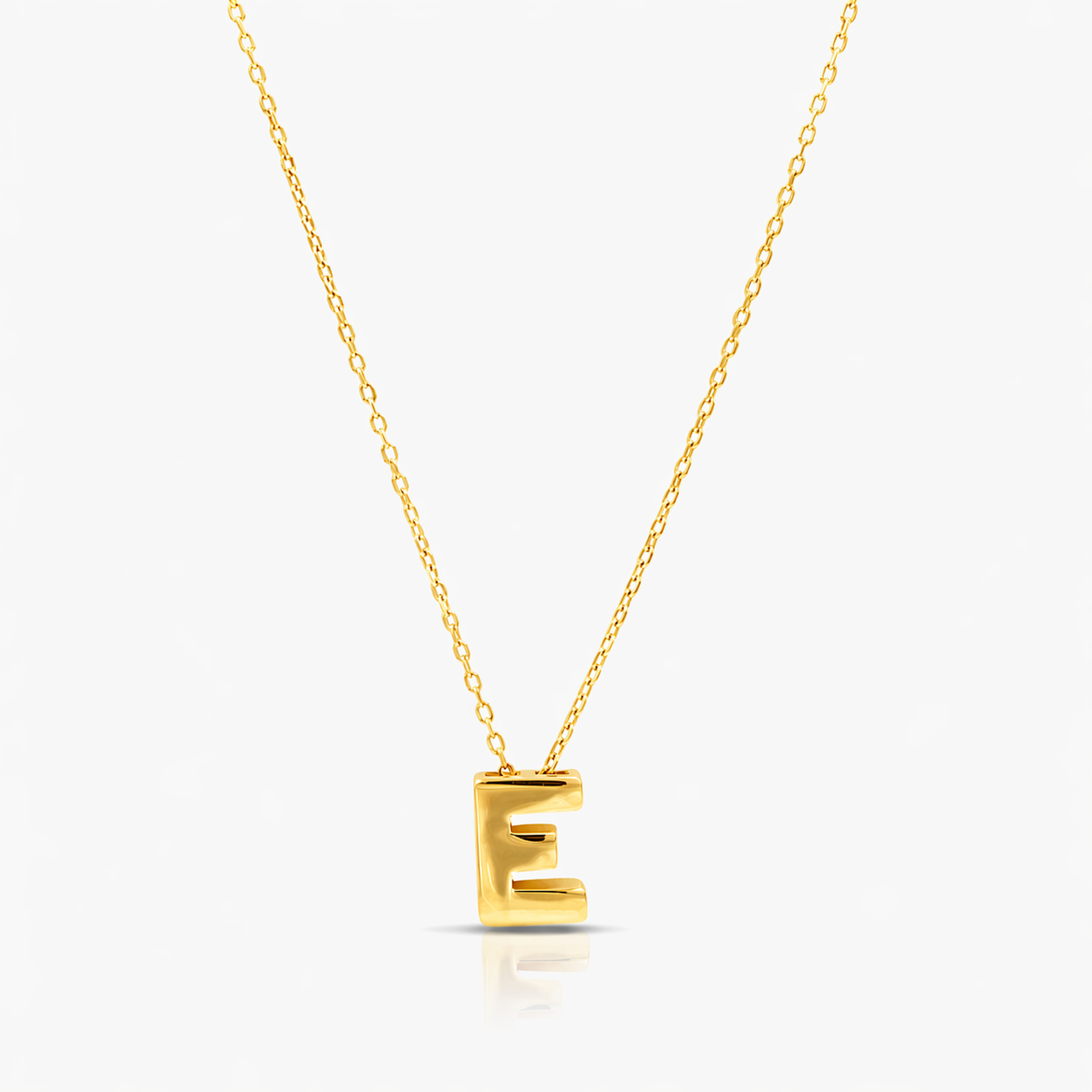 Gold necklace with a 'E' pendant on a white background