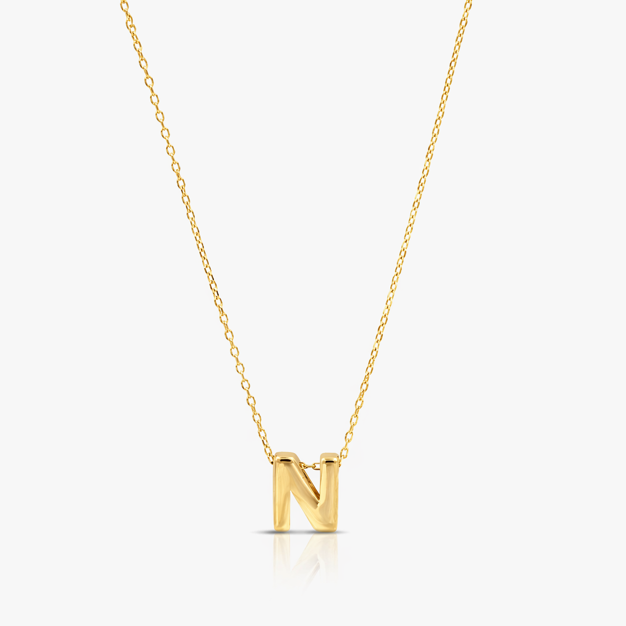 Gold necklace with a 'N' pendant on a white background